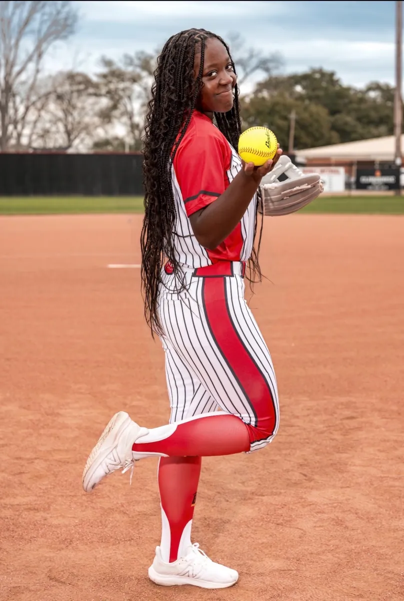 Kennedi Fair in her Brusly High School pinstripe uniform, glove and softball in hand, posed on the field