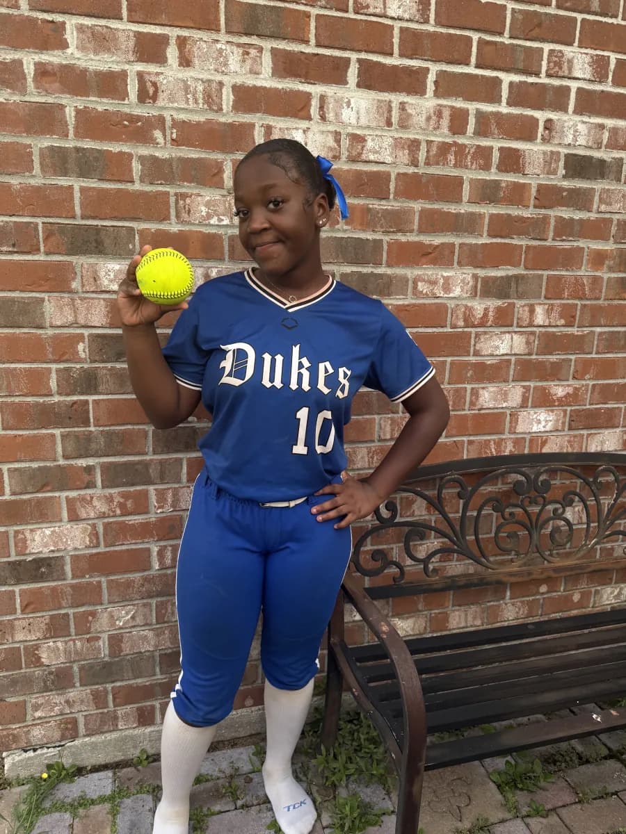 Kennedi Fair (#10) in her royal blue Louisiana Lady Dukes uniform holding a softball