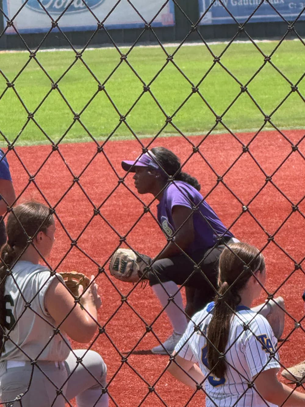 Kennedi Fair set in her fielding stance in her purple XLR8 uniform and visor