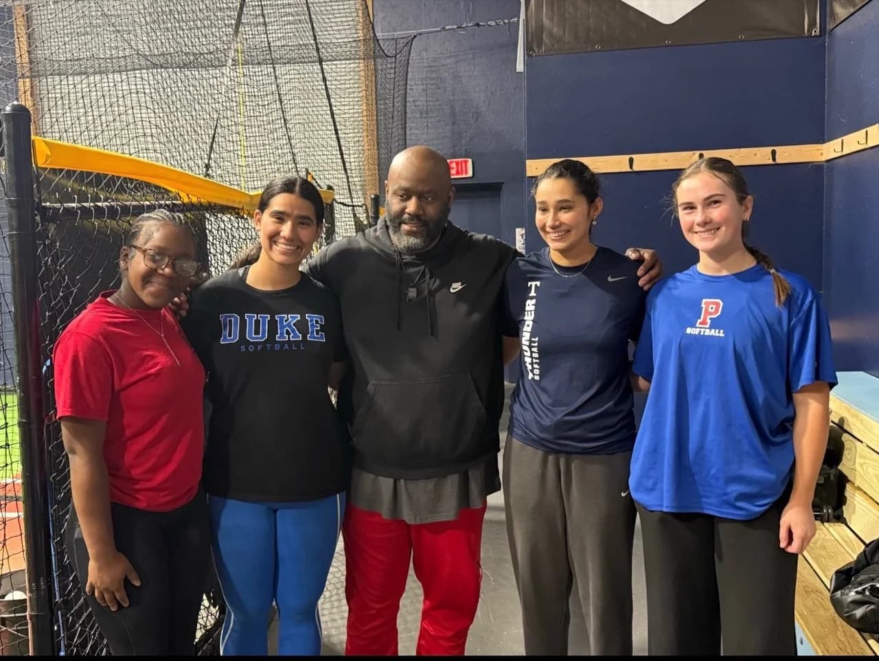 Kennedi Fair with teammates and hitting coach Trae Duncan at 3D Sports.